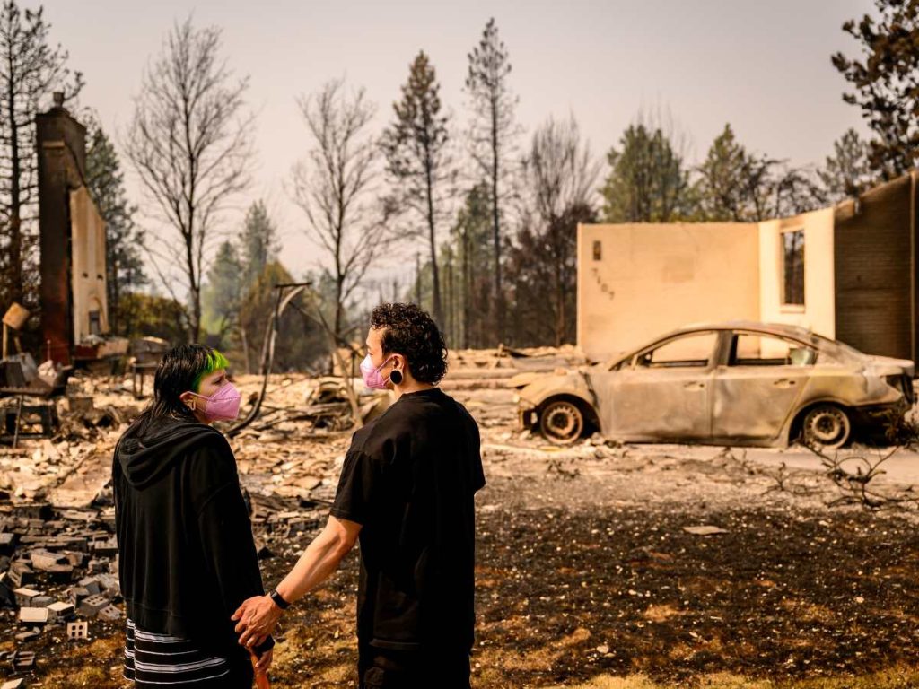Una pareja observa su casa destruida por el incendio de Old Trails en Spokane, Washington, el 4 de agosto de 2026.

