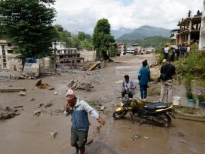 Campesinos avanzan entre el lodo en Trishuli, en el distrito nepalí de Nuwakot, tras una riada repentina. EFE/EPA/NARENDRA SHRESTHA