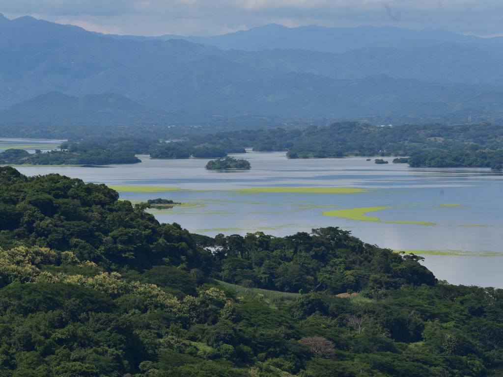 Una vista amplia del lago Suchitlán con sus islas, enmarcada por montañas azules en el horizonte.