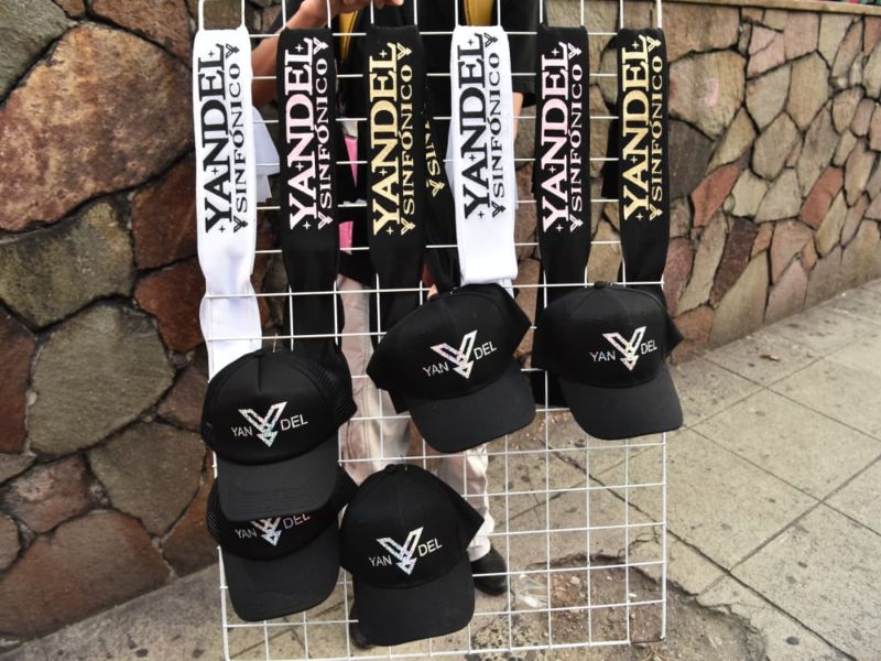 Camisas, gorras y binchas alusivas a Yandel se ofrecen afuera del Estadio Cuscatlán como recuerdos del concierto.