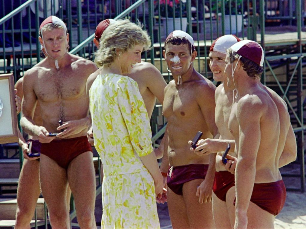 La princesa Diana de Gales intercambia comentarios el 31 de enero de 1988 con miembros del equipo ganador del "Plato Princesa de Gales", el Trofeo Especial de Salvamento Marítimo, en la playa de Terrigal, al norte de Sídney. (Foto de Patrick RIVIERE / AFP)