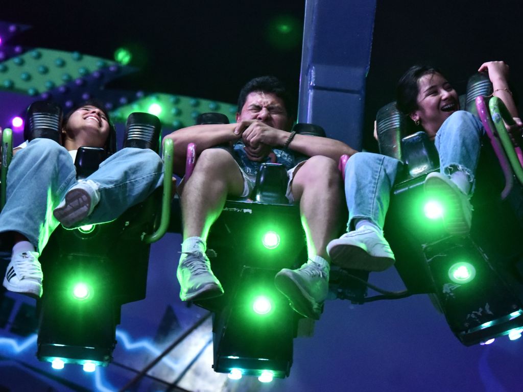 Con los pies en el aire estos jóvenes se aferran al juego mecánico.