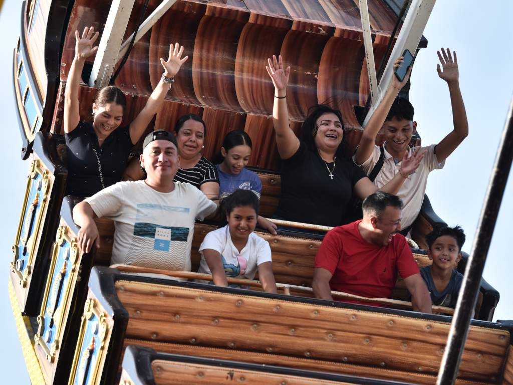 Familias y amigos saludan entusiasmados mientras se mecen a bordo del barco pirata.