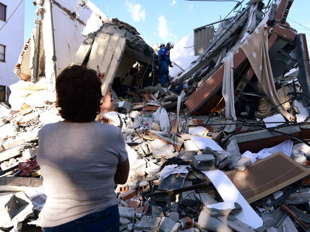Una mujer observa a los rescatistas que buscan sobrevivientes entre los escombros de un edificio derrumbado tras un terremoto en Pereira, Colombia, el 10 de agosto de 2026.