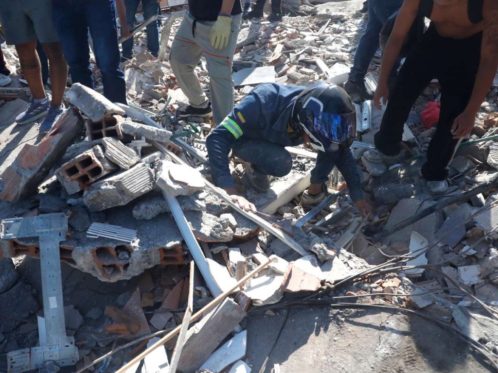 Una persona busca en los escombros de un edificio colapsado este lunes, en Cali (Colombia).