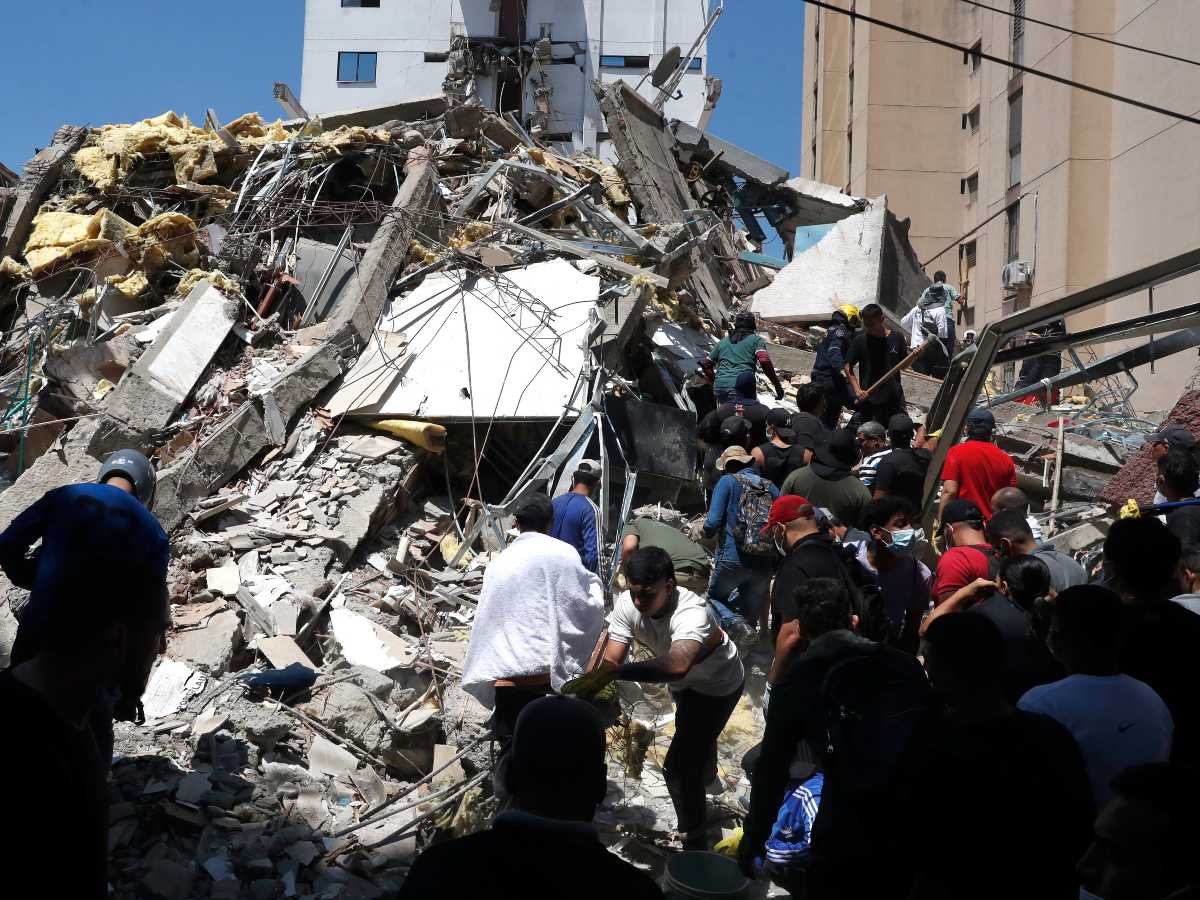 Integrantes del cuerpo de Bomberos de Cali y civiles buscan entre los escombros de edificaciones colapsadas por el terremoto de magnitud 7,4 que sacudió esta mañana el país, este lunes en Cali (Colombia).
