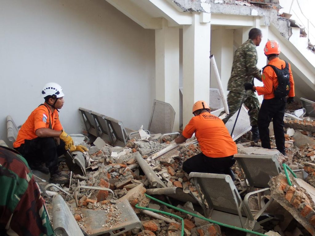 Rescatistas trabajan entre los escombros de un edificio dañado por el terremoto de magnitud 7.7 que sacudió el este de Indonesia. Foto / AFP