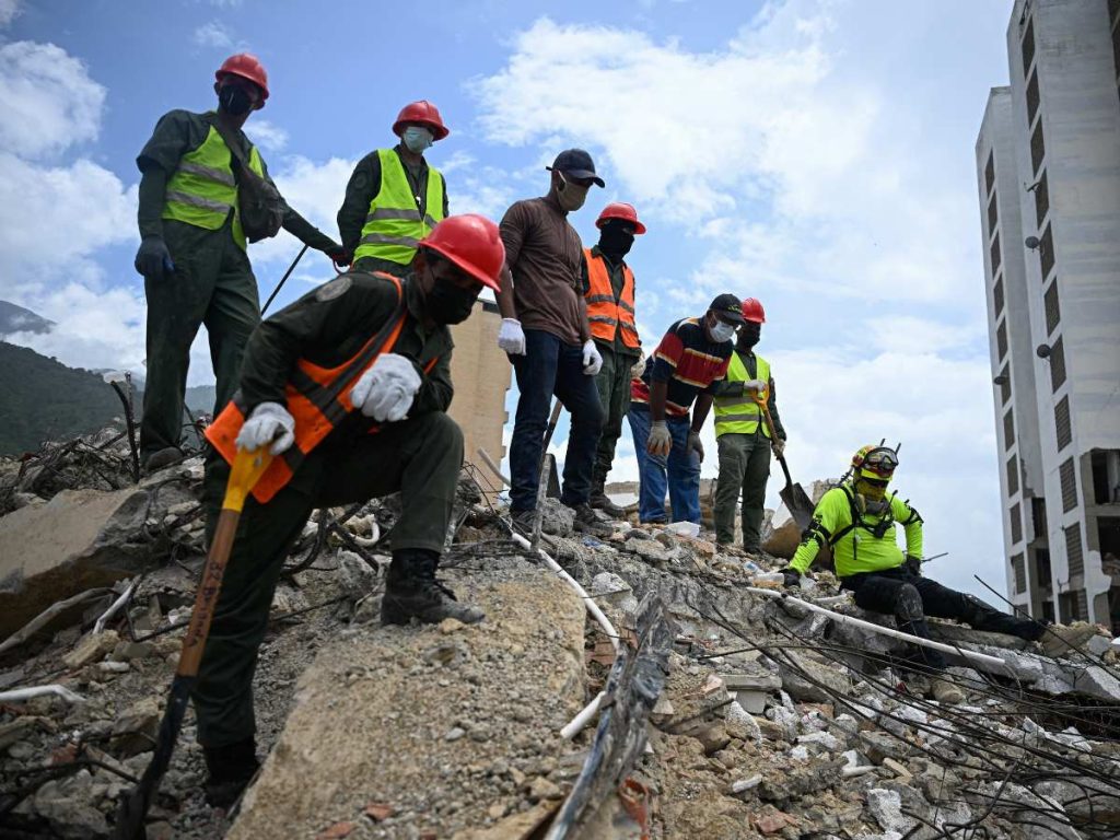 Equipos de rescate y voluntarios buscan cuerpos entre los escombros de un edificio derrumbado en Caraballeda, Venezuela, el 3 de agosto de 2026. (Foto de Federico PARRA / AFP)