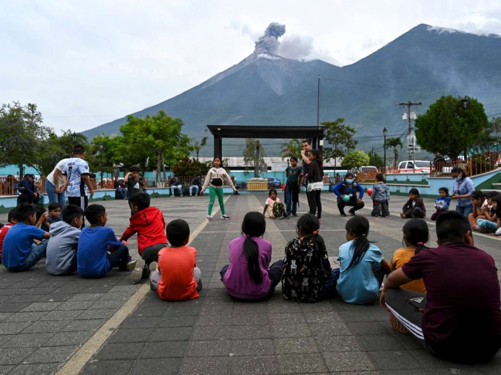 Niños se reúnen mientras el volcán de Fuego entra en erupción en Alotenango, Guatemala. AFP/Johan Ordóñez