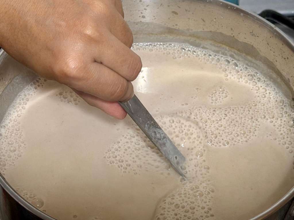 Mamá Tere preparando atol madrugadoramente en grandes ollas en su cocina.
