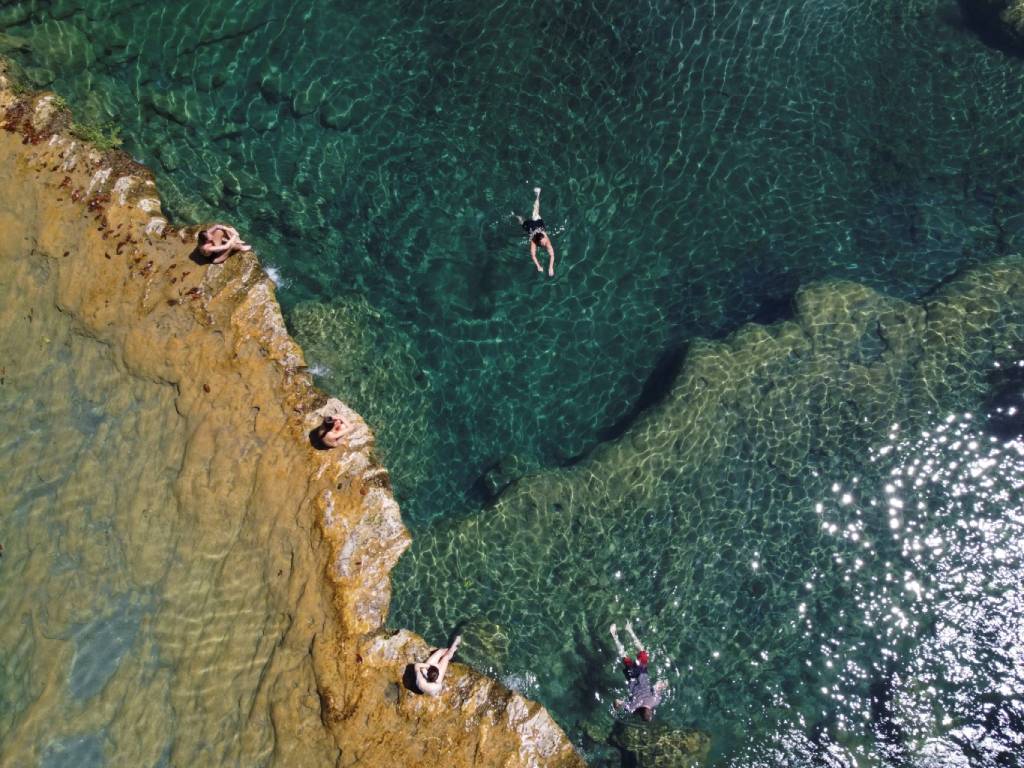 Vista aérea de personas nadando en las piletas naturales de agua turquesa del Parque Nacional Semuc Champey.
