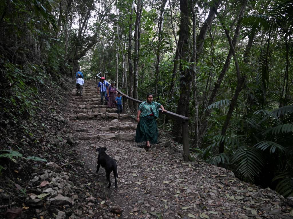 Habitantes locales caminando por los caminos rurales del entorno natural en Semuc Champey.