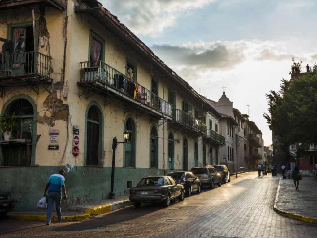 Escena callejera en el Casco Viejo con arquitectura colonial, adoquines y transeúntes paseando.