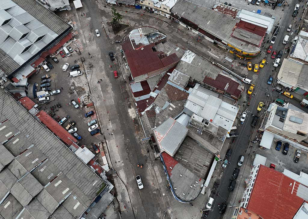 Vista aérea en ángulo picado sobre los techos metálicos del Mercado Central y calles asfaltadas sin puestos de venta.