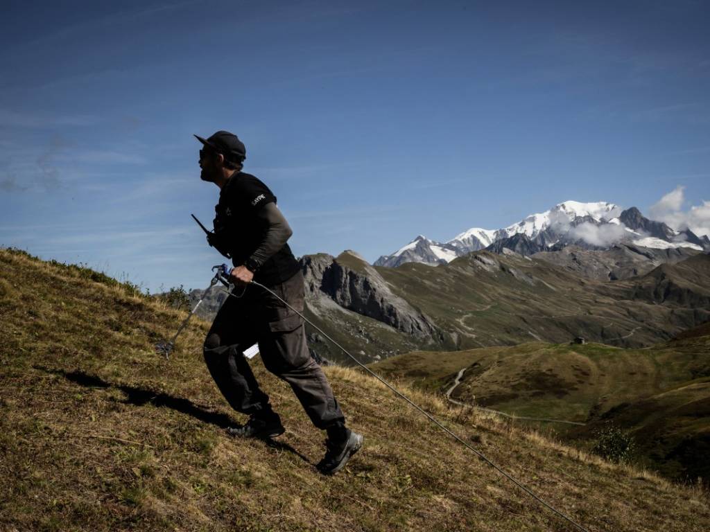 Fotografía del artista Saype trabajando al aire libre, representando su transición del grafiti al arte en la tierra.