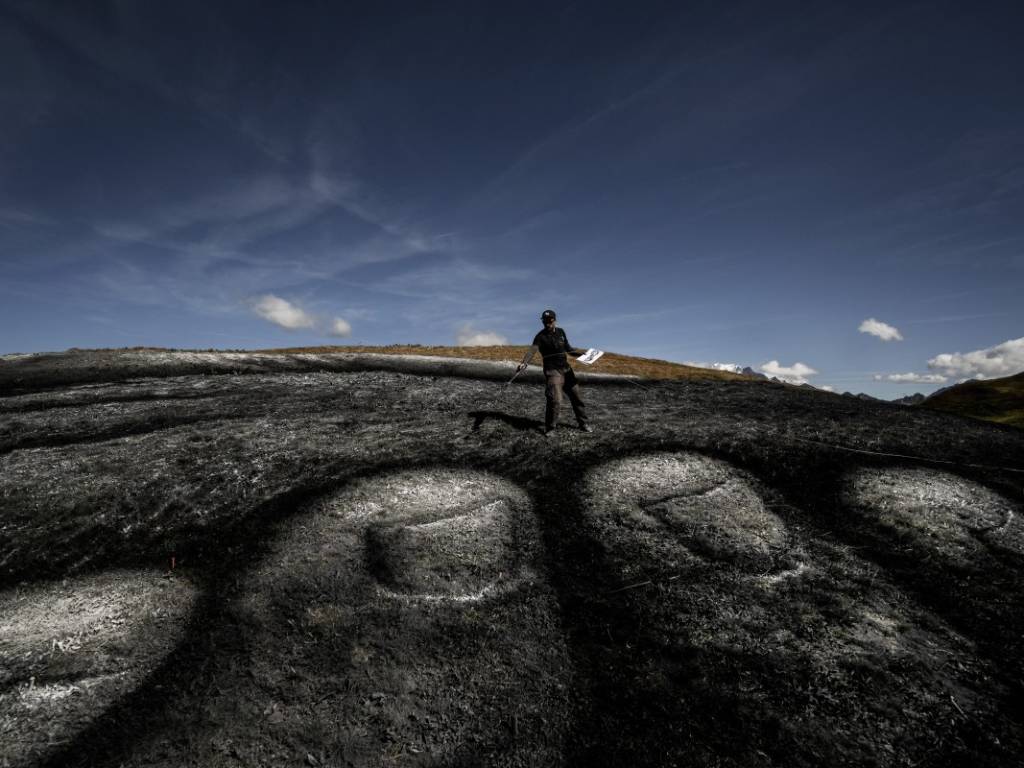 Fotografía que ilustra la naturaleza efímera del mural sobre la hierba, diseñado para desaparecer de forma ecológica.