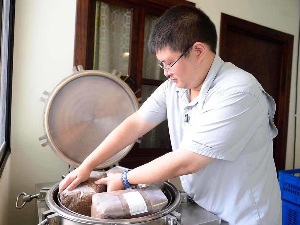 Otto Tang Chen preparando el autoclave para esterilizar sustrato de hongos en Viveros Merliot El Salvador.