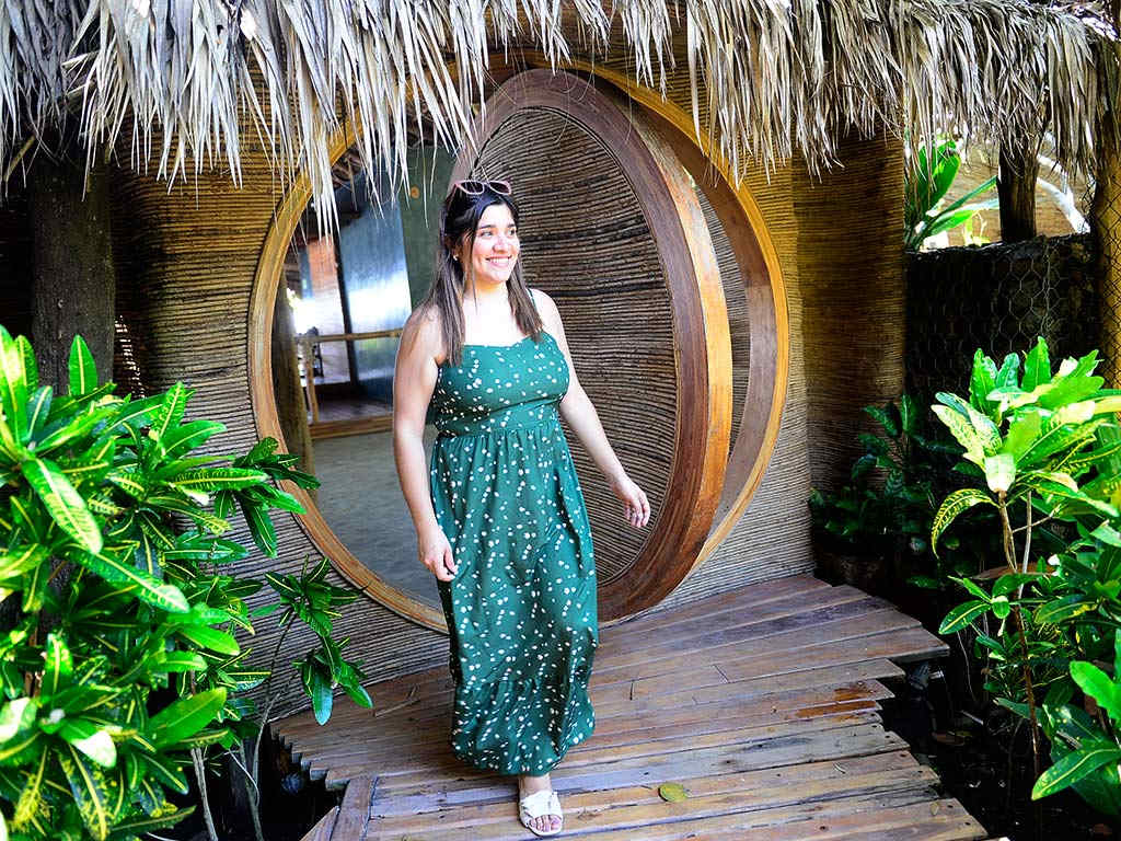 Huésped caminando hacia la entrada de diseño circular en madera y bambú de MIZATA by Antiresort en La Libertad El Salvador.