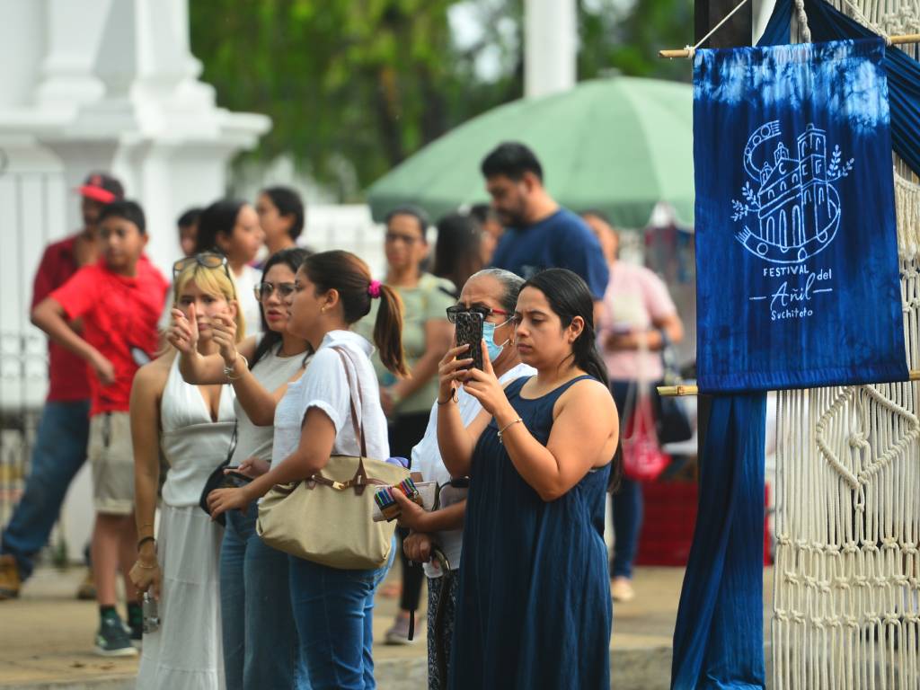 Modelos lucen prendas y vestidos artesanales teñidos de azul añil sobre una pasarela.