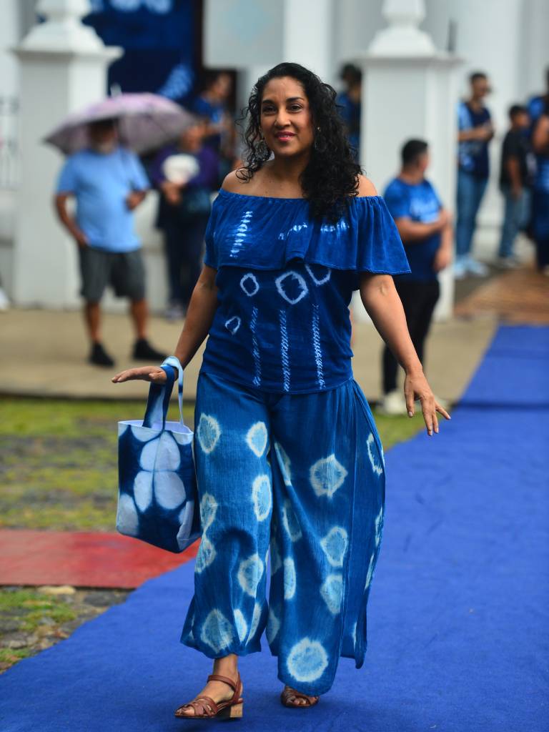 Conjunto femenino de blusa y falda azul teñido con añil, acompañado de un bolso elaborado con fibras textiles.