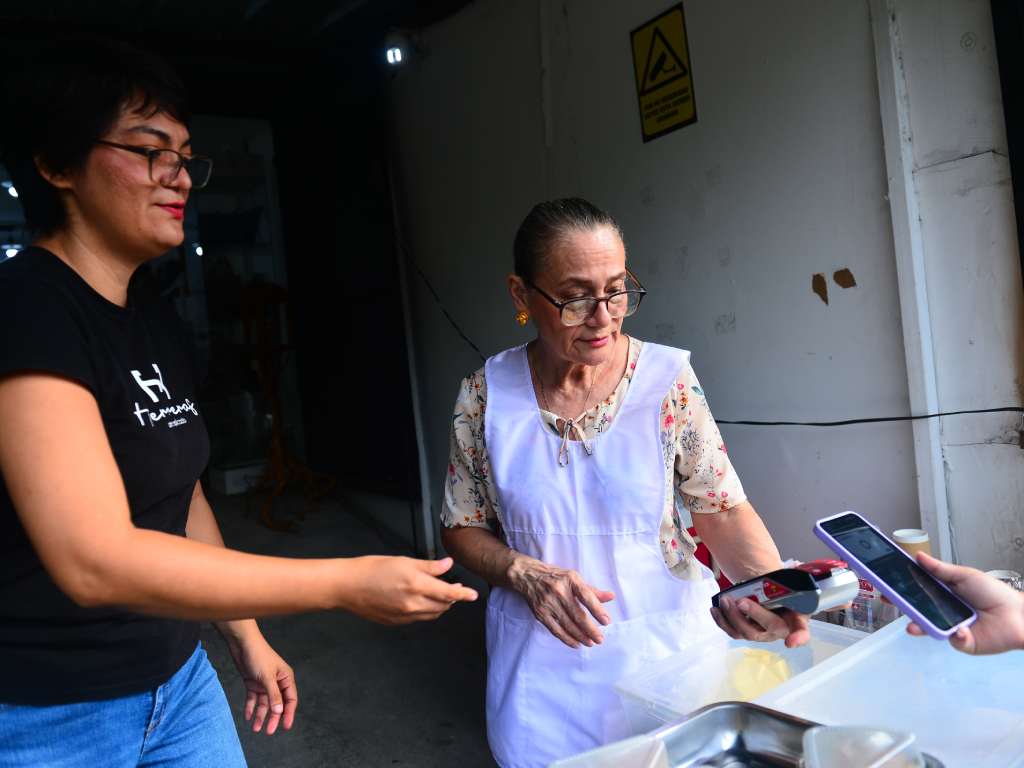Mamá Tere adaptada a la tecnología cobra un producto a su cliente.