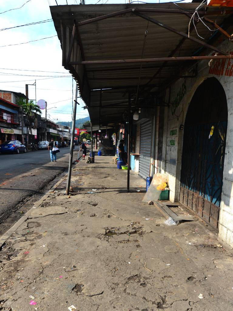 Vendedores informales desmontando por cuenta propia las estructuras metálicas de sus puestos en la vía pública.