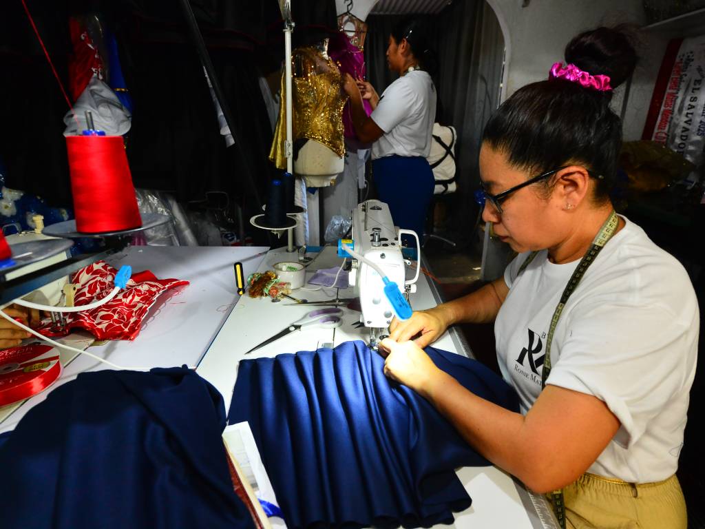 Nidia Mendoza, madre del diseñador Roni Matías, trabajando concentrada en la confección de prendas dentro del taller.