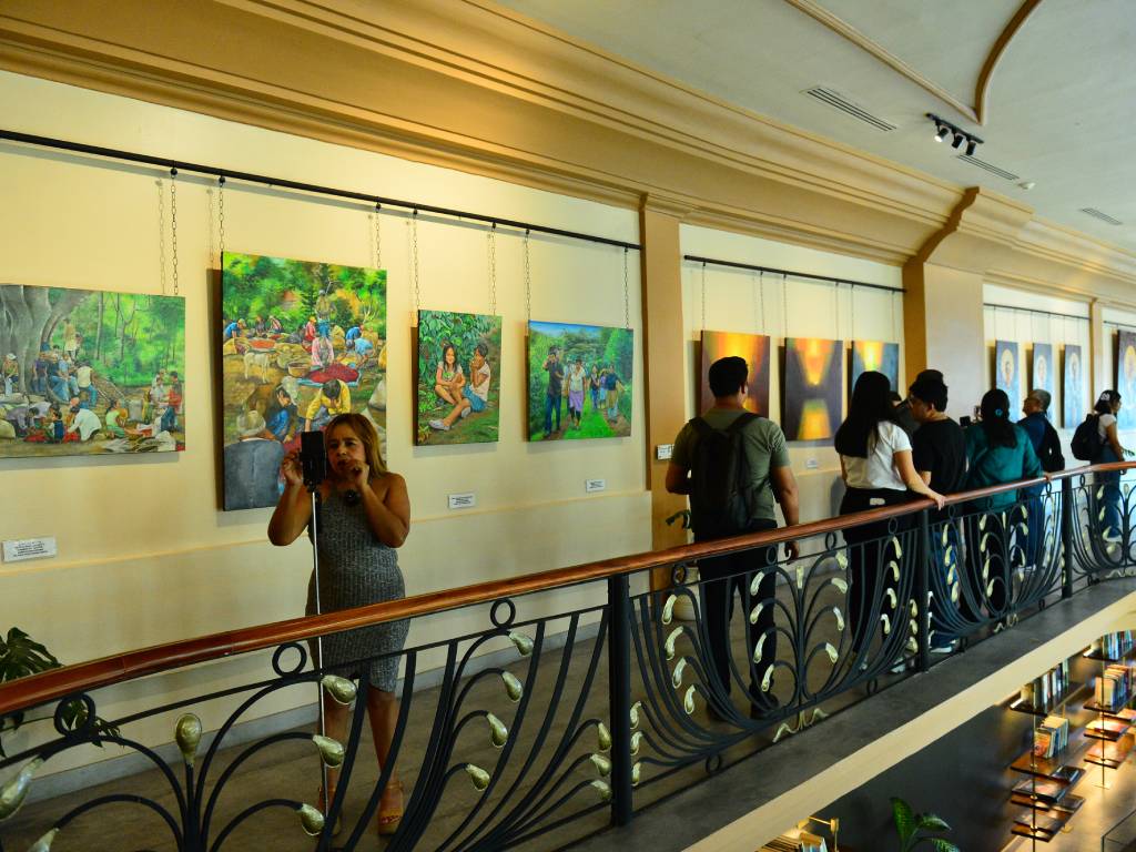 Periodistas y creadores de contenido tomando fotografías y notas en la sala de la exposición.