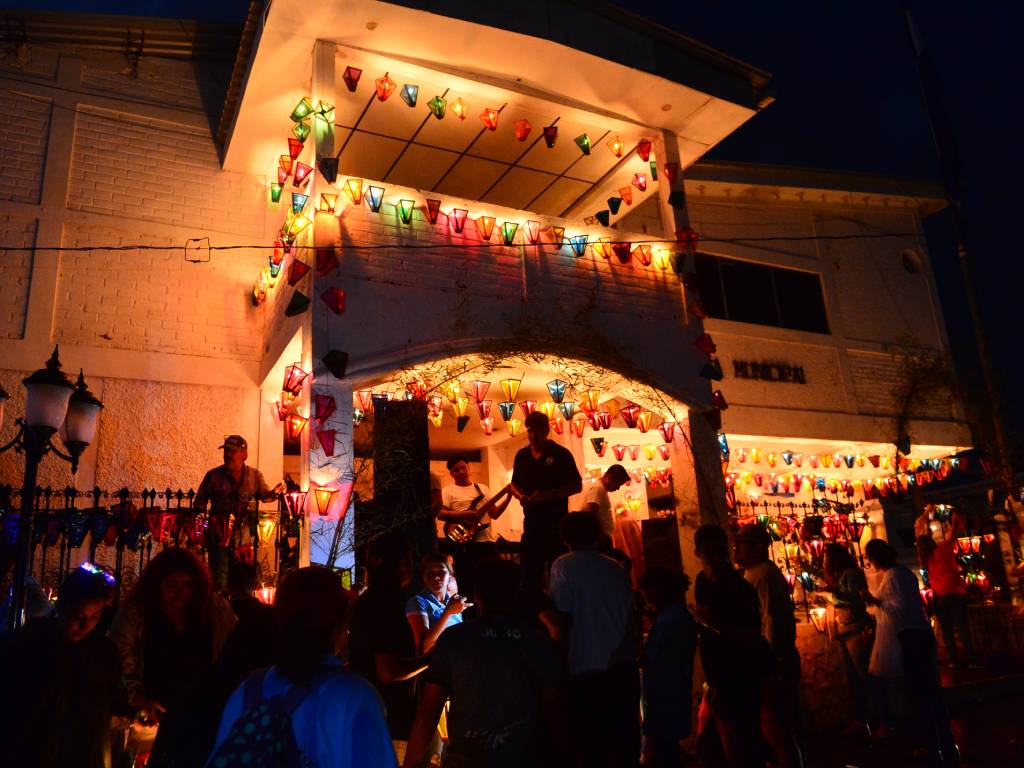 Fachada del palacio municipal de Concepción de Ataco decorada con multitud de farolitos de colores encendidos.