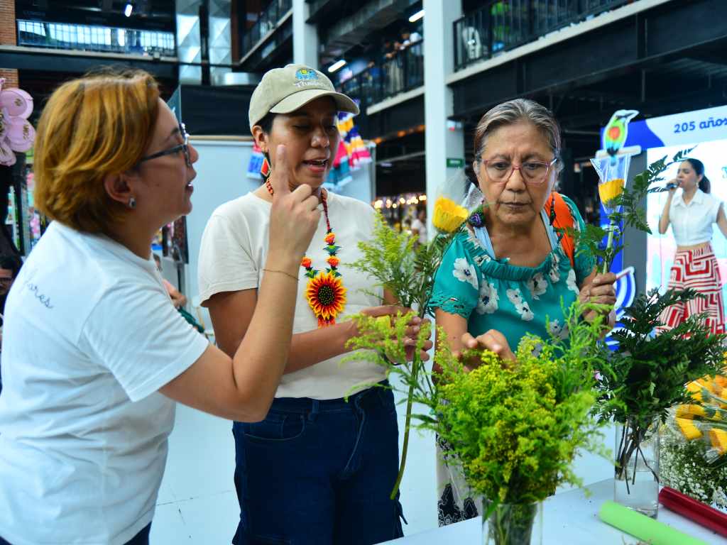 Visitantes seleccionando distintas variedades amarillas para armar su propio bouquet en el flower bar.