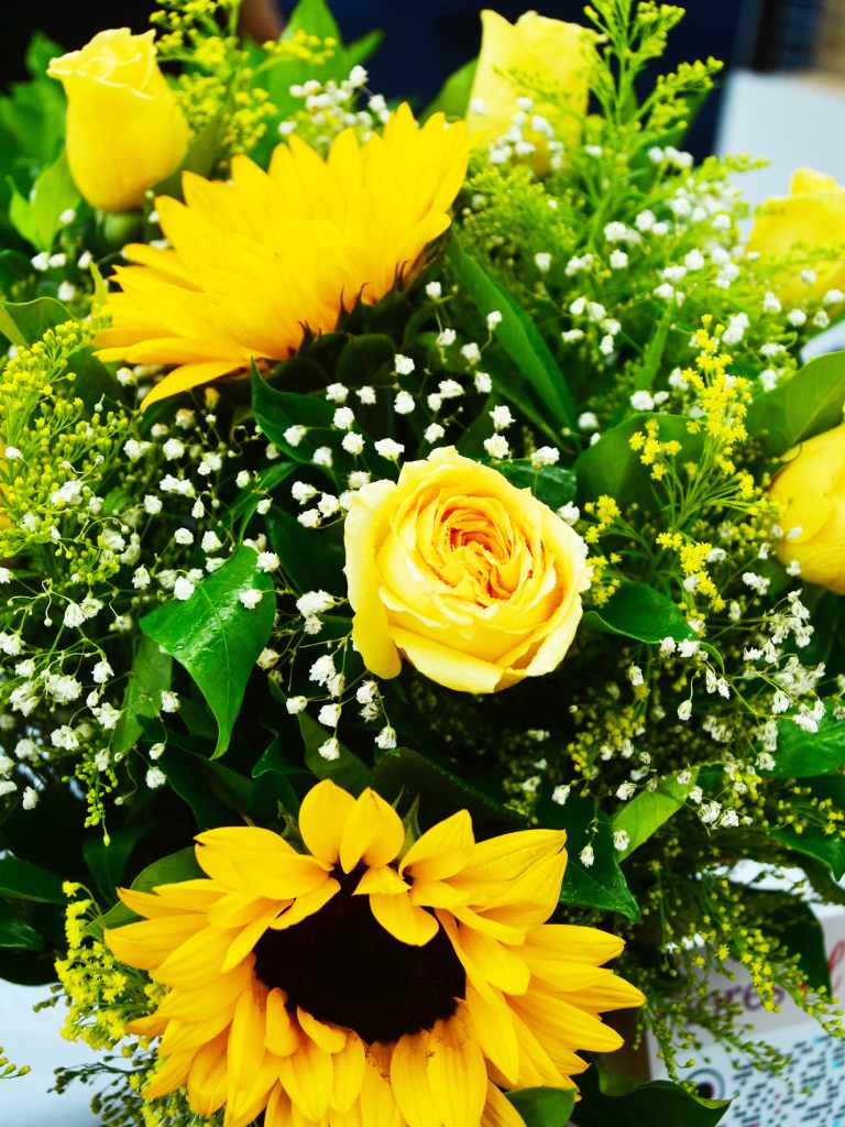 Muestra de arreglos con flores amarillas exhibidos con precios que van desde los 4 hasta los 20 dólares.