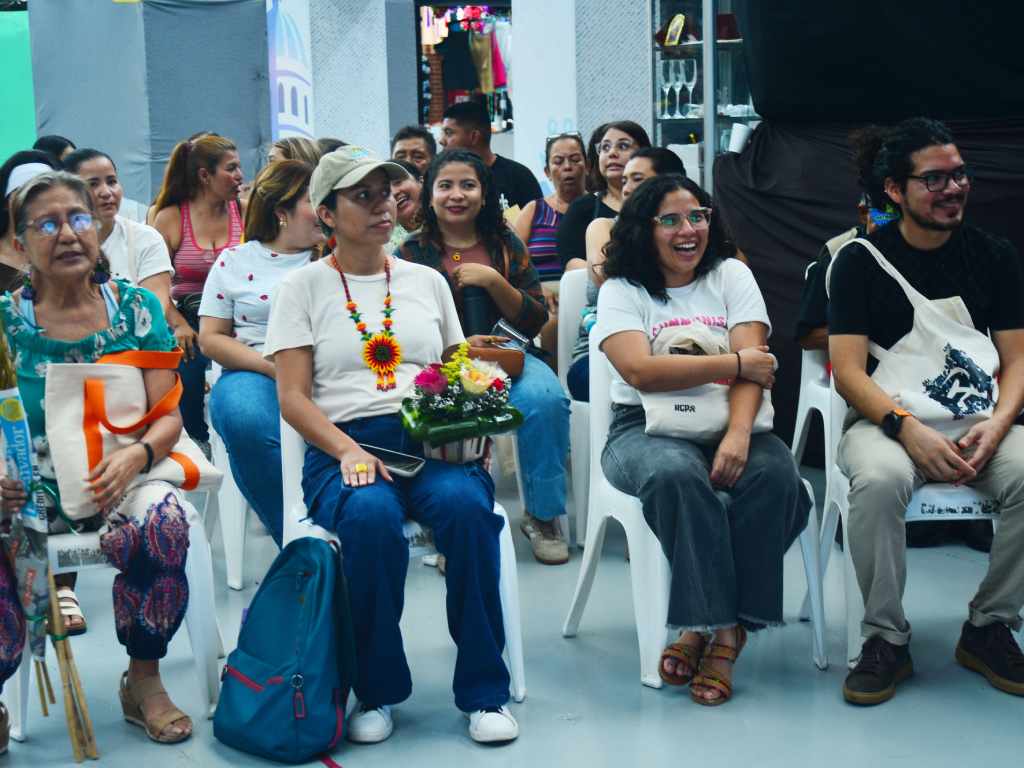 Grupo de personas haciendo fila ante un estand decorado con arreglos amarillos a la espera de armar su bouquet.