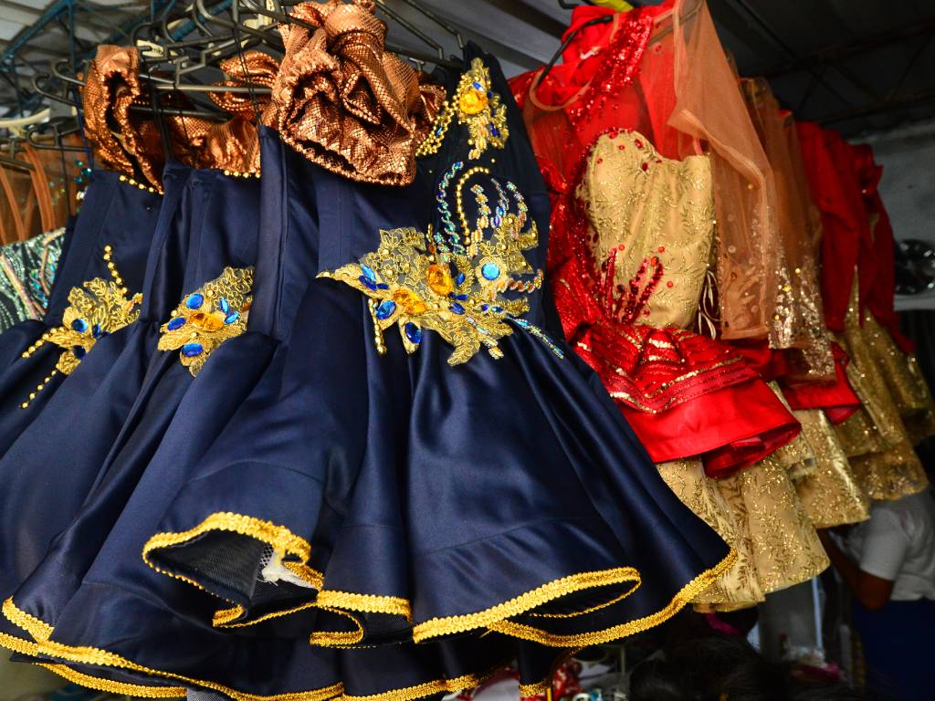Fila de trajes de cachiporra terminados y planchados, colgados en el taller esperando la entrega a las delegaciones.