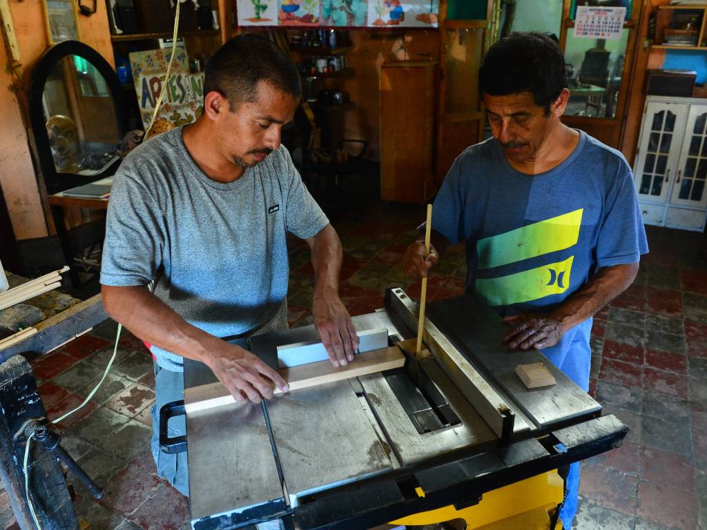 Artesano realizando el corte de piezas de madera como primer paso para armar el farolito.