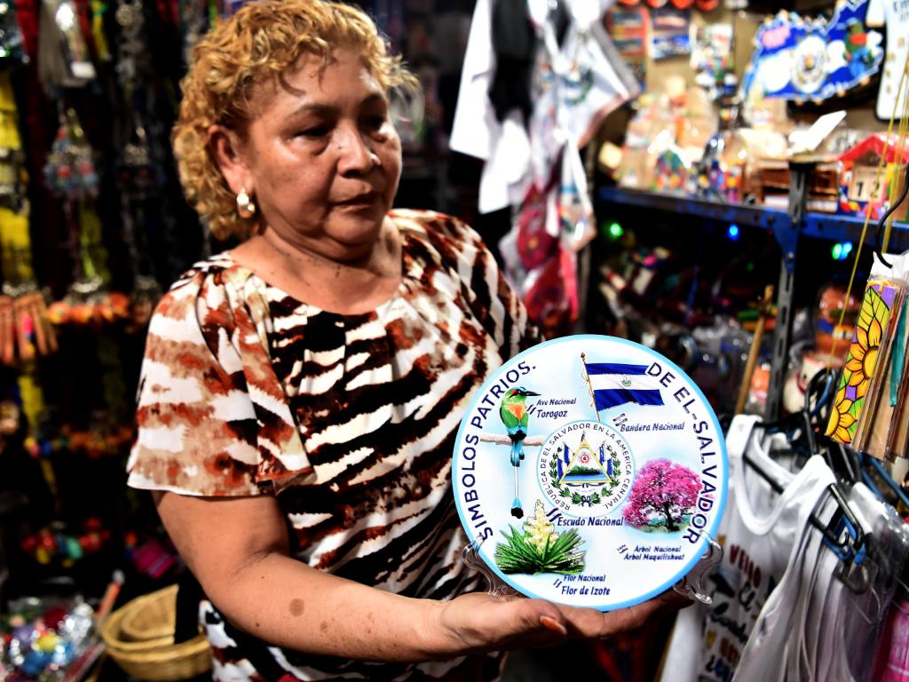Artesana exhibe un adorno circular con los símbolos patrios de El Salvador.