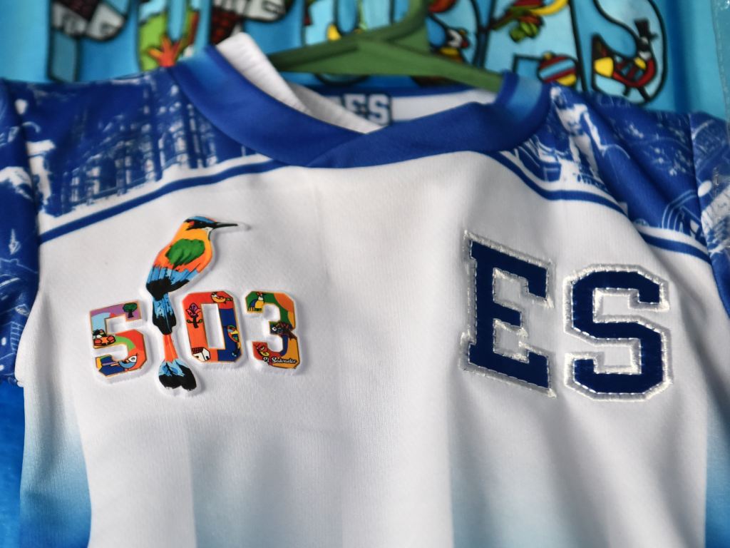 Primer plano de una camiseta blanca con el Torogoz, el 503 y la sigla ES.