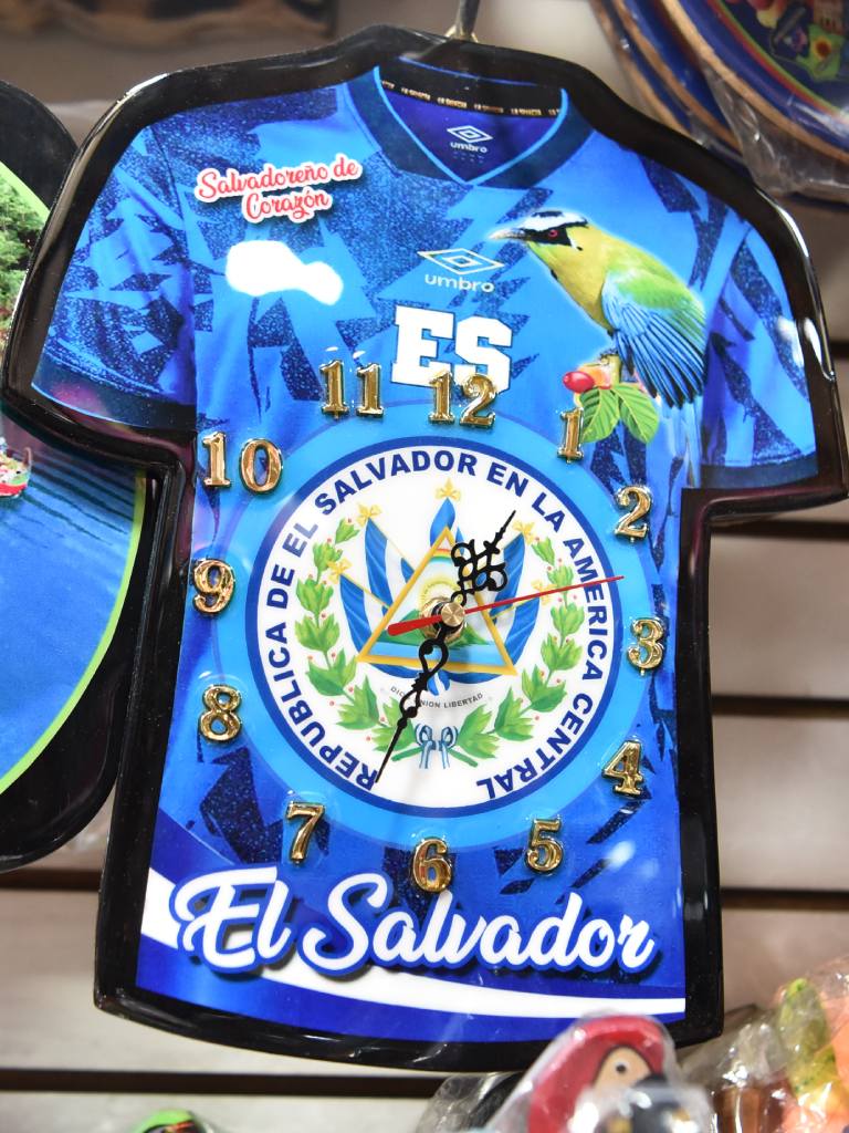 Reloj de pared con forma de camiseta de la Selecta y el escudo nacional en el centro.