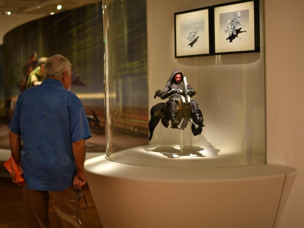 Un visitante observa una maqueta detallada de Darth Maul sobre su Sith Speeder expuesta en una sala del Museo Lucas.
