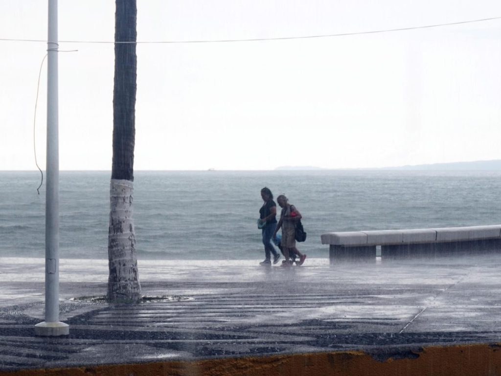 Personas caminan este martes en el malecón de Puerto Vallarta (México). El huracán Polo