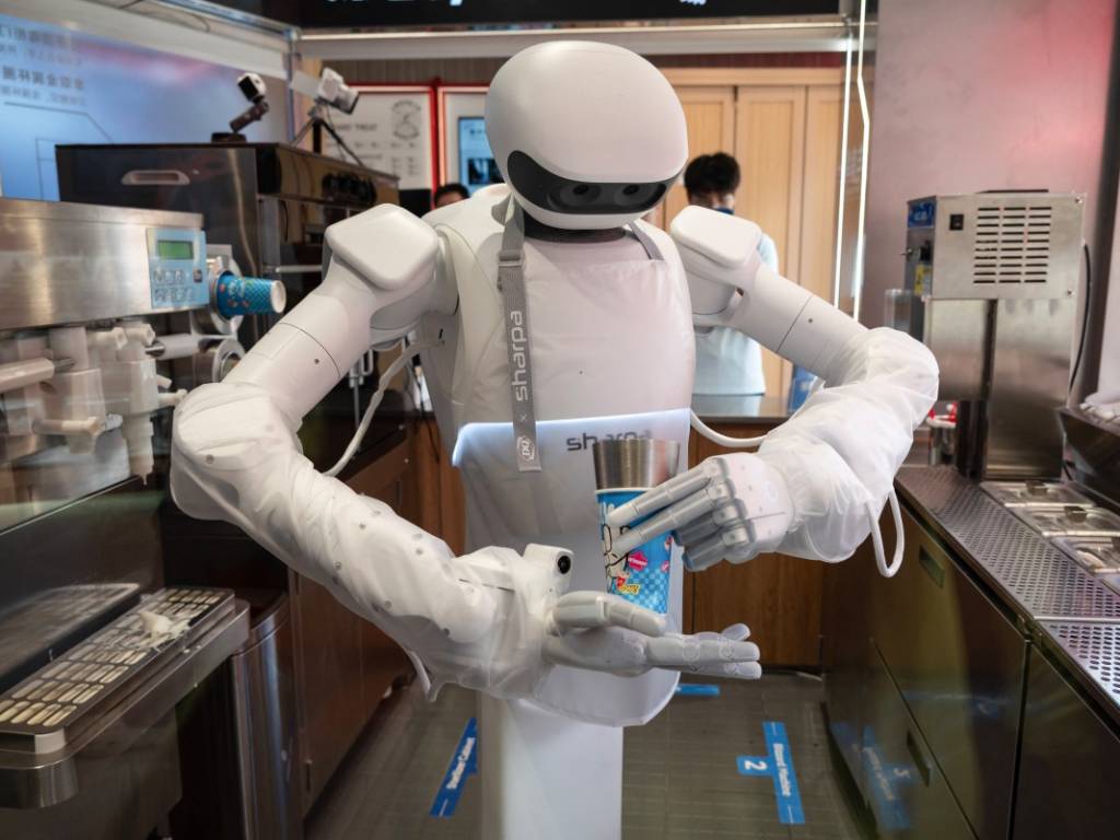 El robot humanoide completando el proceso de elaboración de un helado sobre la barra de servicio.