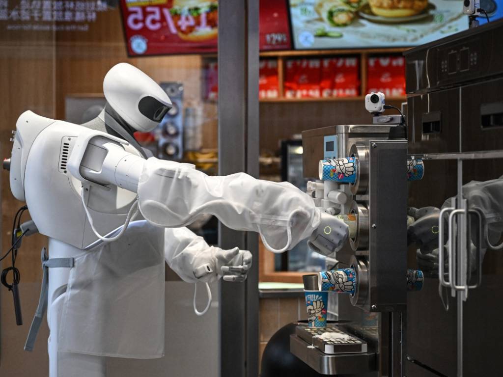 Vista en detalle del robot humanoide ejecutando la secuencia automatizada de pasos para preparar un helado.