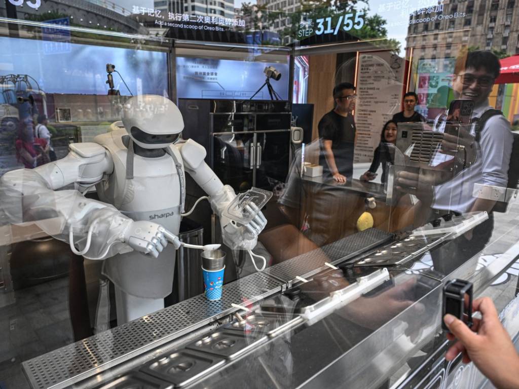 Detalle de las yemas de los dedos del robot sujetando un vaso de papel con firmeza y delicadeza.