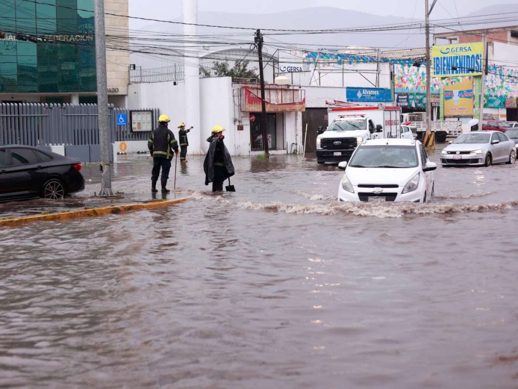 Bomberos atienden una emergencia en calle inundada debido a las fuertes lluvias en Pachuca (México). EFE/David Martínez Pelcastre