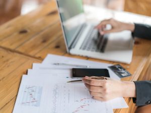 Business woman hand with Financial charts and laptop on the table