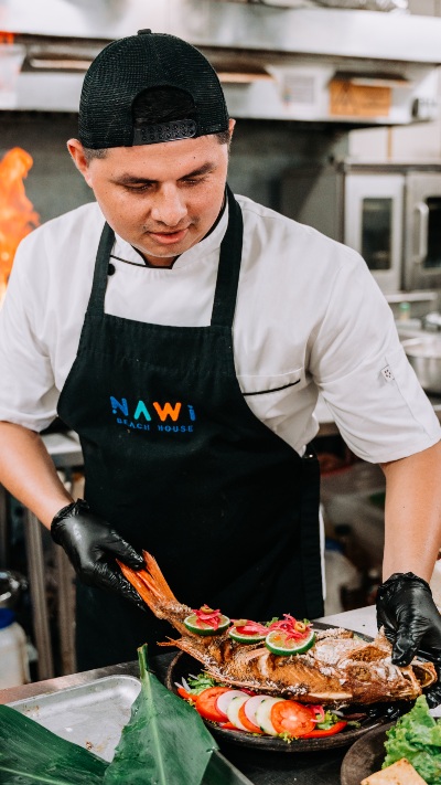 David Gutiérrez prepara pescado fresco en la cocina de NAWI Beach House, donde los productos del mar tienen un papel protagonista.