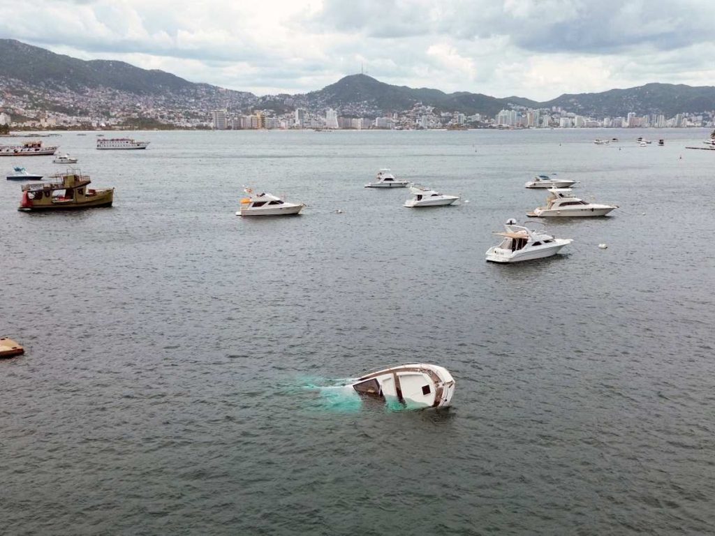 Una embarcación quedó parcialmente sumergida en la bahía de Acapulco por el fuerte oleaje y los vientos asociados al huracán Polo.