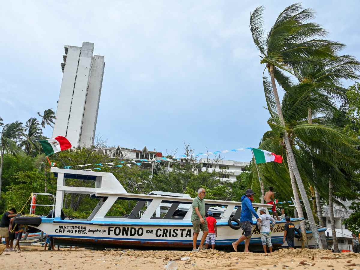 Pescadores aseguran una embarcación en Acapulco ante la cercanía del huracán Polo, que alcanzó categoría 5 en menos de 24 horas.