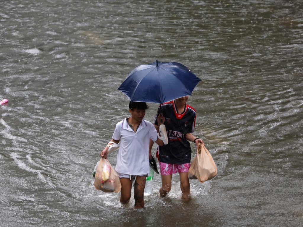 Residentes transportan alimentos mientras caminan entre agua por la calle Petchaburi, una importante arteria de la capital tailandesa, cuyos 50 distritos han sido declarados zonas de desastre por inundaciones tras las intensas y continuas lluvias provocadas por un fuerte sistema de baja presión, sumado a los patrones estacionales del monzón. EFE/EPA/RUNGROJ YONGRIT