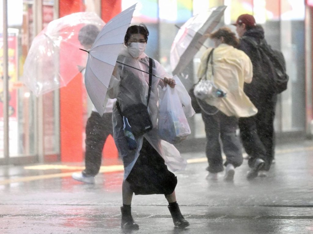 Una peatona se aferra a su paraguas en medio de fuertes vientos y lluvias torrenciales en Chiba el 21 de septiembre de 2026.