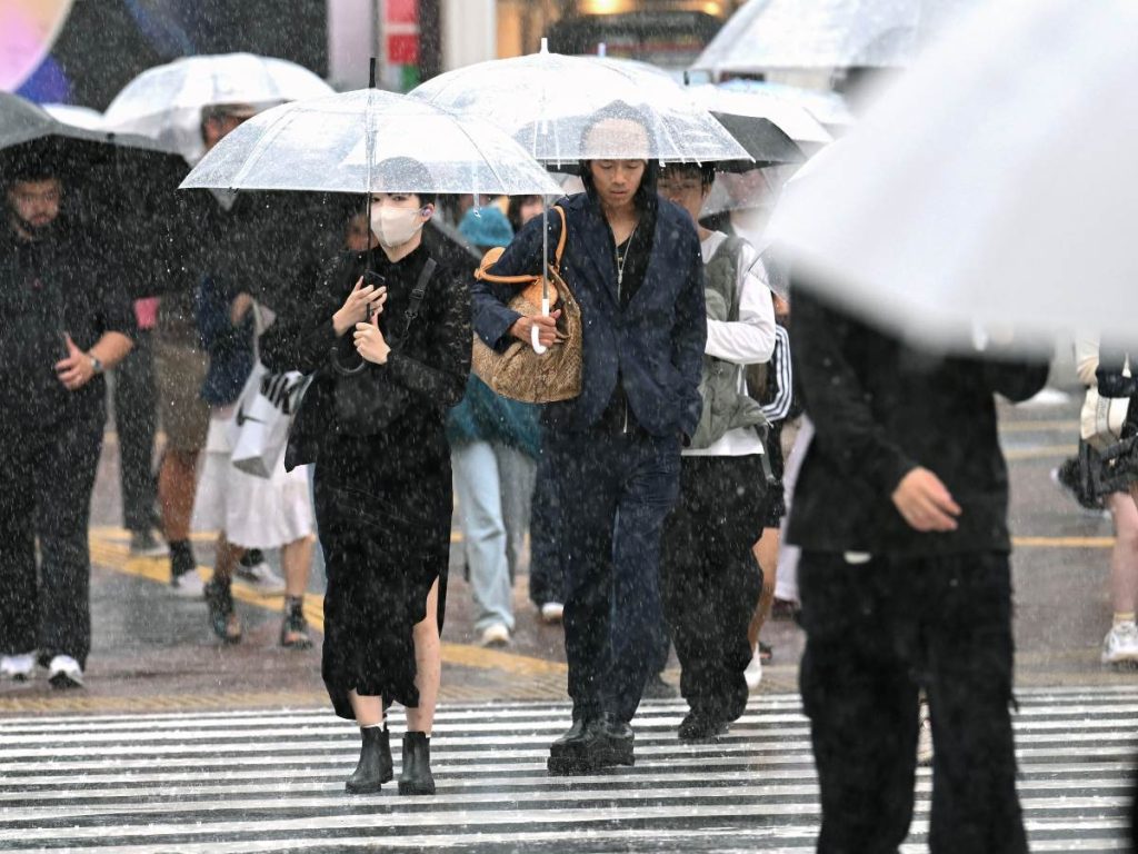 Peatones con paraguas cruzan una calle en medio de fuertes lluvias en el distrito de Shibuya, Tokio, el 21 de septiembre de 2026.